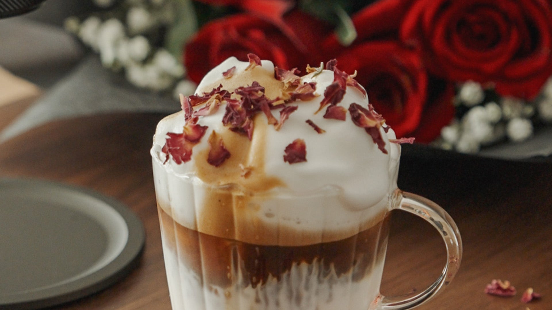 Nahaufnahme eines geschichteten Kaffeespezialgetränks in einer gerippten Glastasse