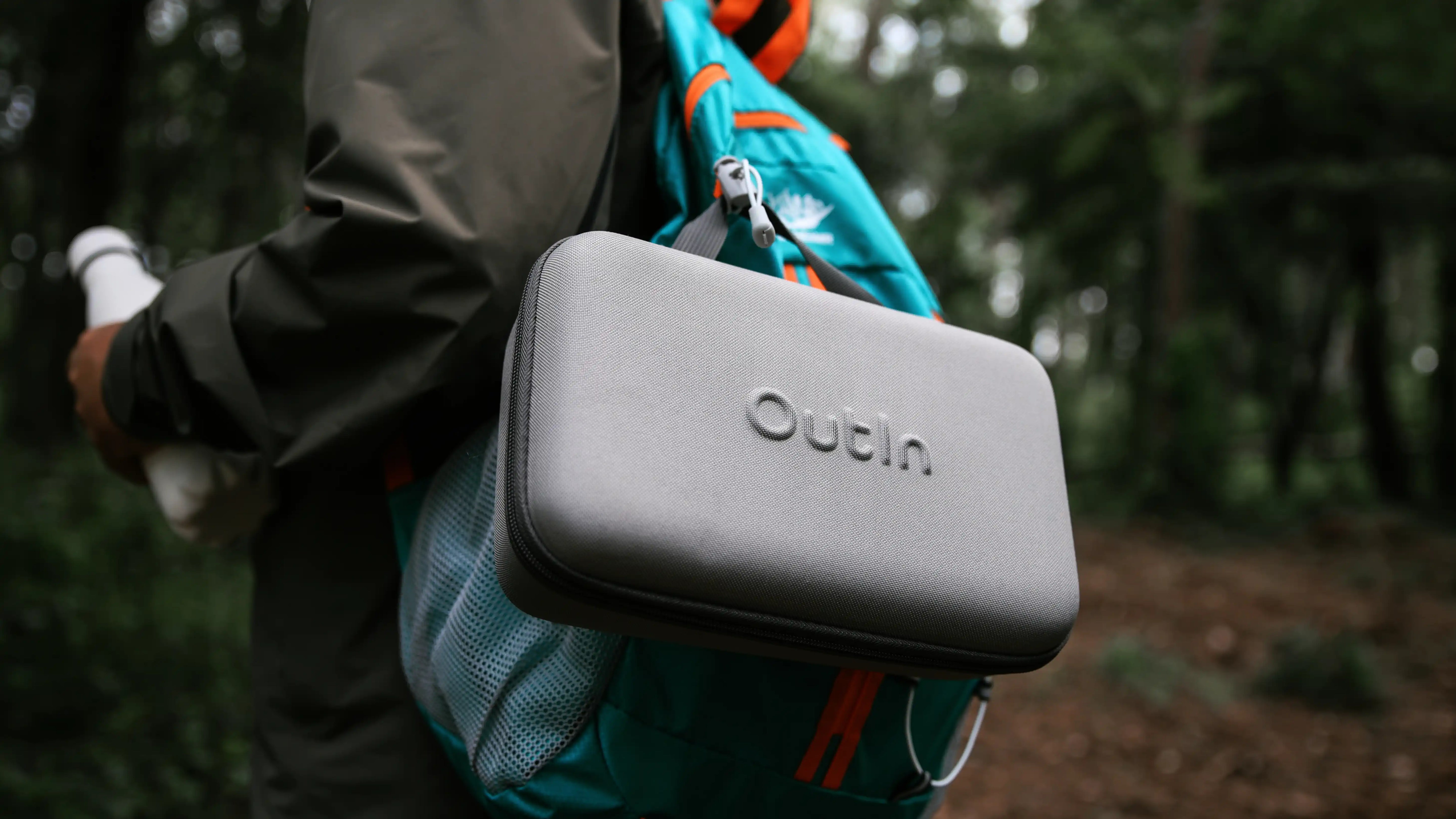 Robustes graues Outin Travel Case für mobile Espressomaschine am Wanderrucksack