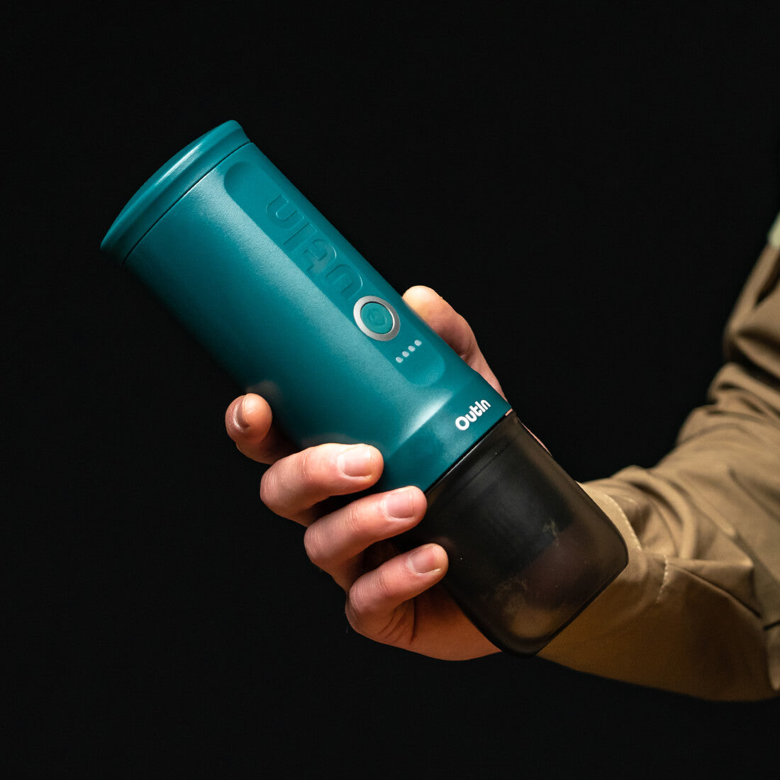 Teal Outin Nano Portable Espresso Machine being held, emphasizing portability.