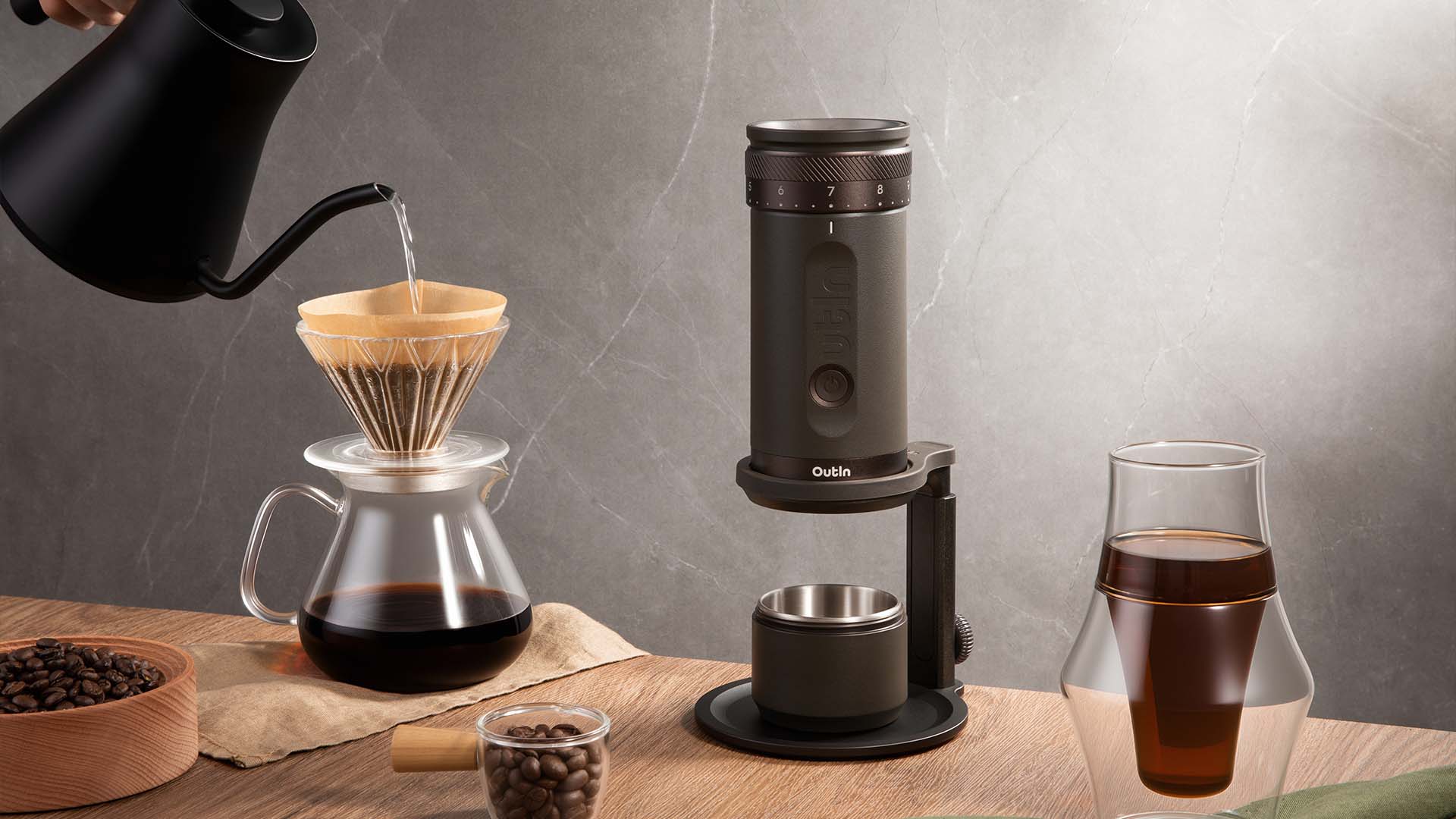 Manuelle Kaffe Zubereitung mit Aufgussmethode, bestehend aus Outin-Kaffeemühle, Glaskaraffe und frisch gemahlenem Kaffee auf dem Tisch – ein Spezialitätenkaffee-Zubereitungsprozess.