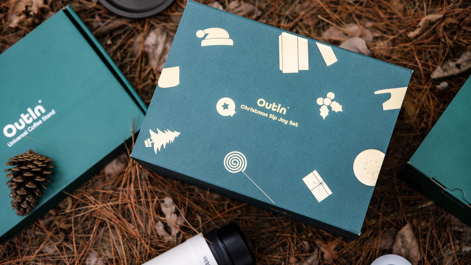 Outin Nano portable Espressomaschine im Geschenkset mit Zubehör auf Holzgrund.