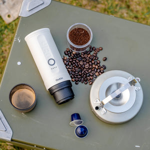 Pearl White Nano Portable Espresso Machine with accessories on green surface.